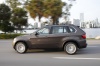 Driving 2013 BMW X5 xDrive50i in Sparkling Bronze Metallic from a left side view